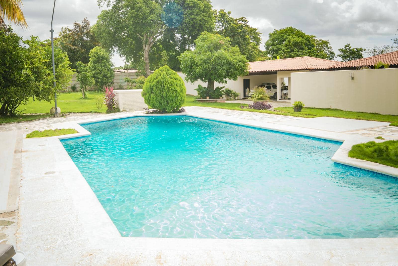 An image of a crystal clear and beautiful home swimming pool on a sunny day