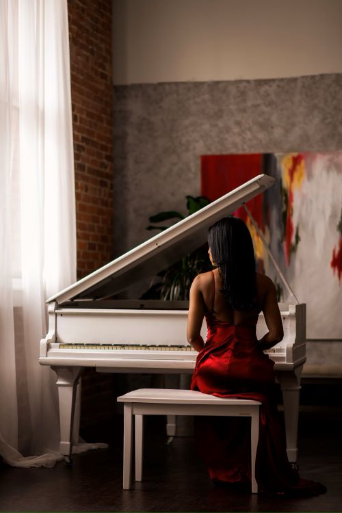 a woman in a red dress is playing piano 