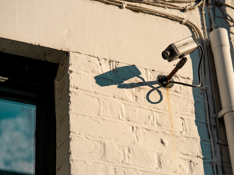 A security camera on a brick wall